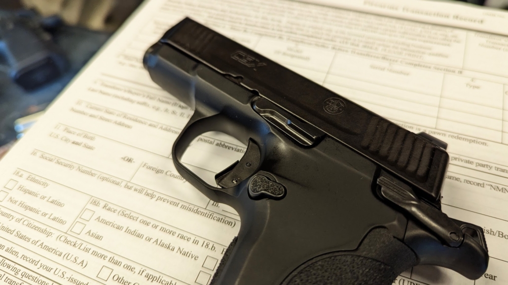A Smith & Wesson CSX set on top of FFL Transfer paperwork 